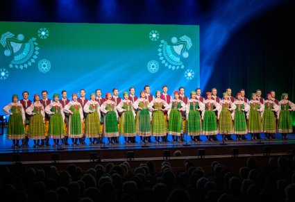 Na scenie Artyści chóru w kostiumach kurpiowskich podczas śpiewu