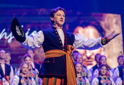 Solista chóru podczas występu na koncercie, w tle widoczny chór