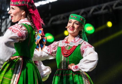 Artystki na scenie w kostiumach kurpiowskich