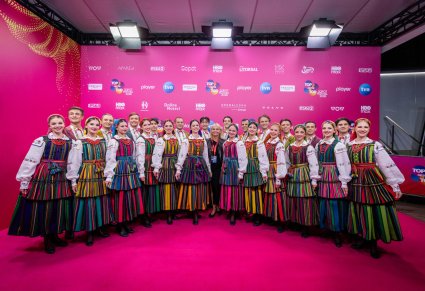Artyści baletu w kostiumach opoczyńskich razem z kierownik baletu, podczas zdjęcia na ściance festiwalu