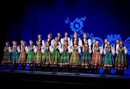 Chór w kostiumach łowickich wykonujący utwór na scenie