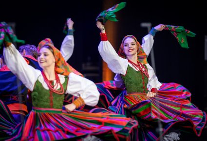 Tancerki w kostiumach sannickich w obrotach na scenie