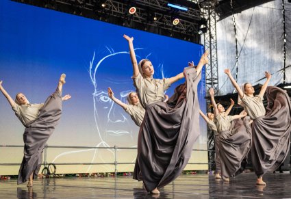 Grupa Artystów w kostiumach współczesnych w trakcie wykonywania choreografii tanecznej
