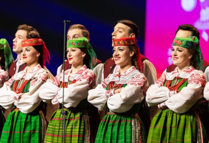 Zbliżenie na Artystów w kostiumach kurpiowskich w trakcie śpiewu