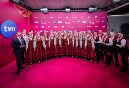 Orkiestra w kostiumach wilanowskich, wraz z dyrygentem podczas zdjęć na ściance festiwalowej