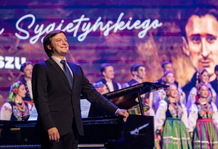 Akompaniator przy fortepianie, w tle widoczny chór