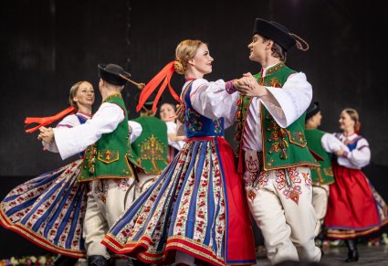Pary Artystów w kostiumach spiskich podczas wykonywania choreografii tanecznej