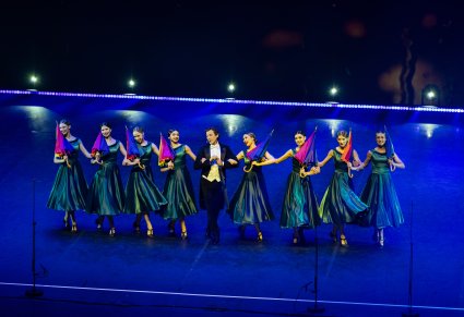 Solista wraz z Tancerkami wykonujący choreografię taneczną z elementem kolorowych parasoli