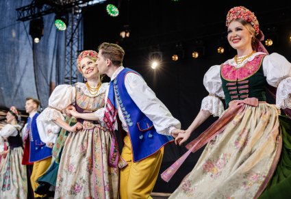 Zbliżenie na trójkę Artystów Tancerzy w kostiumach rozbarskich w trakcie wykonywania choreografii tanecznej