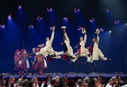 Na scenie Artyści w kostiumach łańcuckich w trakcie wykonywania choreografii tanecznej, niżej widoczna część Orkiestry w kostiumach wilanowskich
