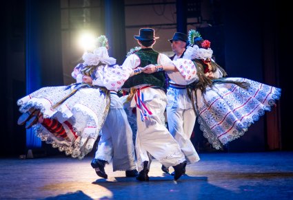Grupa Artystów zespołu z Dubrownika w tradycyjnych kostiumach w trakcie wykonywania choreografii tanecznej na scenie
