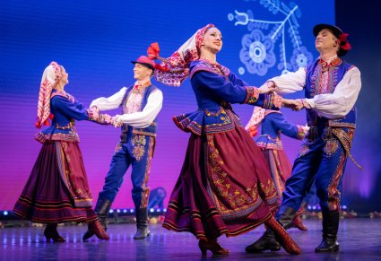 Zbliżenie na dwie pary Artystów w kostiumach podegrodzkich w trakcie wykonywania choreografii tanecznej