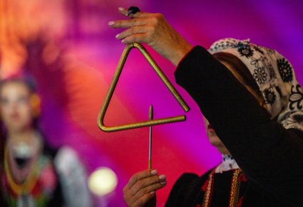 Zbliżenie na Artystkę Orkiestry grającą na trójkącie