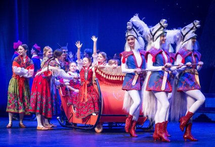 Na saniach Artyści spektaklu wraz z przedszkolakami w kostiumach ludowych. Sanie ciągnięte przez cztery Artystki w kostiumach koni