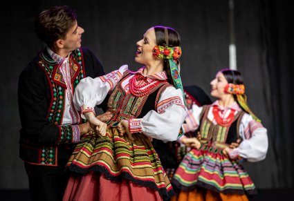 Dwie pary Artystów w kostiumach krzczonowskich na scenie w trakcie wykonywania choreografii tanecznej