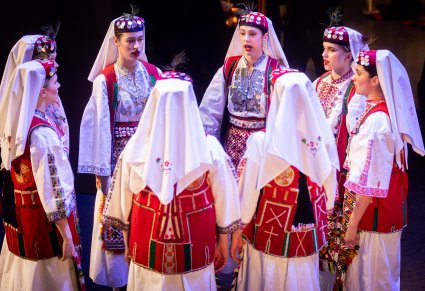 Artystki zespołu z Dubrownika w tradycyjnych kostiumach w trakcie wykonywania choreografii tanecznej na scenie