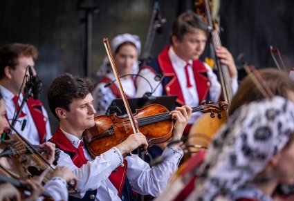 Zbliżenie na Artystów Orkiestry w kostiumach wilanowskich w trakcie grania na instrumentach smyczkowych