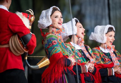 Trzy Artystki na scenie w kostiumach lubuskich wykonujące śpiew