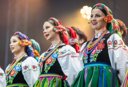 Zbliżenie na Artystki chóru w kostiumach łowickich w trakcie wykonywania śpiewu