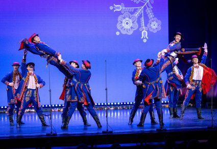 Grupa Artystów w kostiumach podegrodzkich w trakcie wykonywania imponującej choreografii