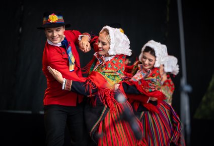 Trzy pary Artystów na scenie w kostiumach lubuskich wykonujący choreografię taneczną