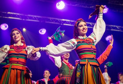 Zbliżenie na tancerki w kostiumach łowickich na scenie