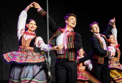 Trzy pary Artystów w kostiumach krzczonowskich na scenie w trakcie wykonywania choreografii tanecznej