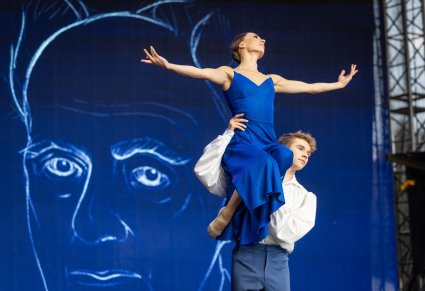Zbliżenie na parę Artystów w kostiumach współczesnych w trakcie wykonywania choreografii tanecznej
