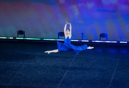 Tancerka w niebieskiej sukience wykonująca choreografię klasyczną