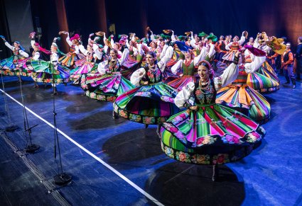 Tancerki w kostiumie łowickim w obrotach na scenie