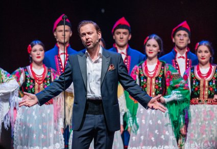 Solista na pierwszym planie a za nim Artyści w kostiumach krakowskich