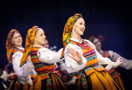 Zbliżenie na Artystki w kostiumach łowickich w trakcie wykonywania choreografii tanecznej
