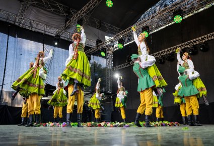 Grupa Artystów w kostiumach lubuskich w trakcie wykonywania choreografii tanecznej na scenie
