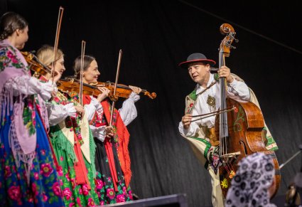 Muzycy orkiestry w kostiumach podhalańskich na scenie