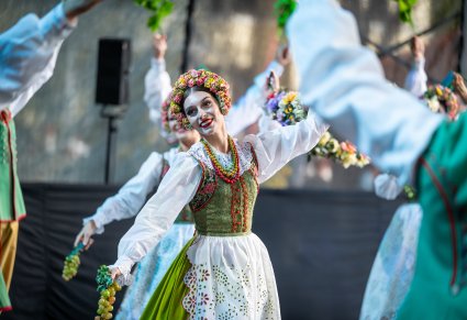 Uśmiechnięte Artystki w kostiumach lubuskich na scenie wykonujący choreografię taneczną