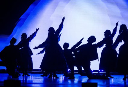 Artyści w kostiumach ludowych na scenie w trakcie choreografii tanecznej