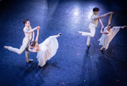 Zbliżenie na dwie pary Artystów w kostiumach współczesnych podczas wykonywania choreografii tanecznej