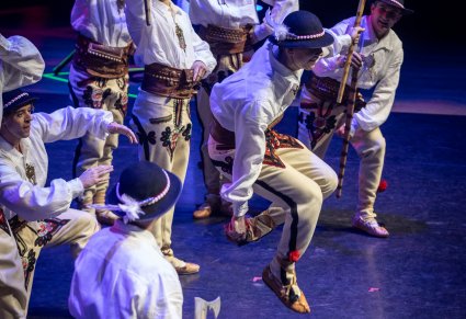 Zbliżenie na tancerzy w kostiumach podhalańskich podczas akrobacji tanecznych