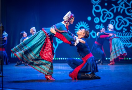 Para taneczna w kostiumach kujawskich w figurze tanecznej na scenie