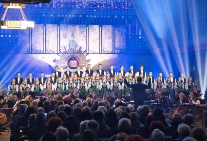 Przed oświetlonym ołtarzem znajdują się Artyści Chóru w kostiumach łowickich, Artyści Orkiestry w kostiumach wilanowskich oraz Dyrygent. Widoczna również część Publiczności