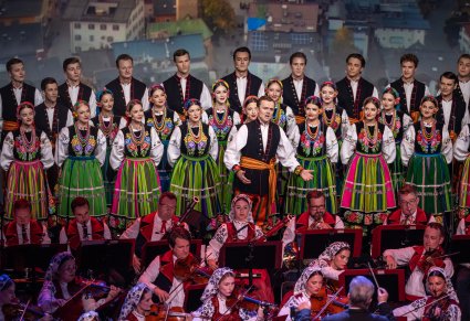 Orkiestra, Solista i Artyści z chóru w kostiumach łowickich ustawieni w rzędach
