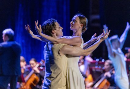 Zbliżenie na dwójkę Artystów Tancerzy w kostiumach współczesnych podczas wykonywania choreografii tanecznej