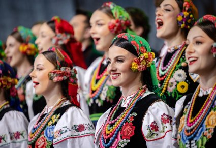 Zbliżenie na Artystki chóru w kostiumach łowickich w trakcie śpiewu