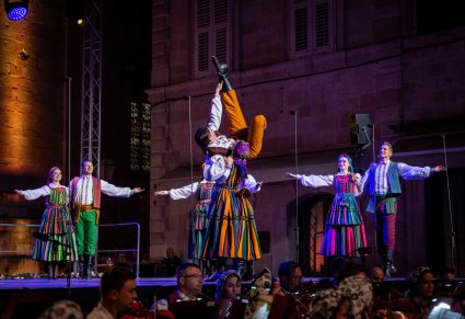 Artyści na scenie w kostiumach opoczyńskich wykonujący choreografię taneczna z imponującymi figurami tanecznymi