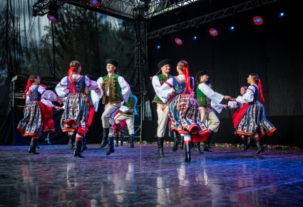Pary Artystów na scenie w kostiumach spiskich trakcie wykonywania choreografii tanecznej
