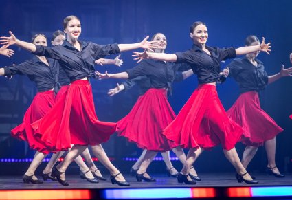Grupa Tancerek w kostiumach współczesnych podczas wykonywania choreografii tanecznej