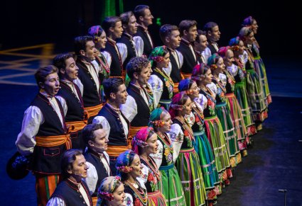 Chór w kostiumach łowickich wykonujący utwór na scenie
