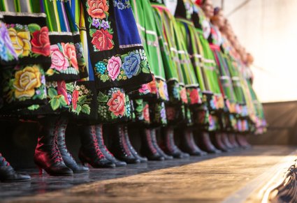 Zbliżenie na dolną część stroju łowickiego kobiecego: buty i spódnice