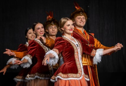 Pary Artystów w kontuszach na scenie wykonujące choreografię taneczną