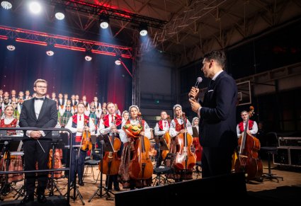 Dyrygent, Orkiestra i chór w kostiumach łowickich podczas zakończenia koncertu